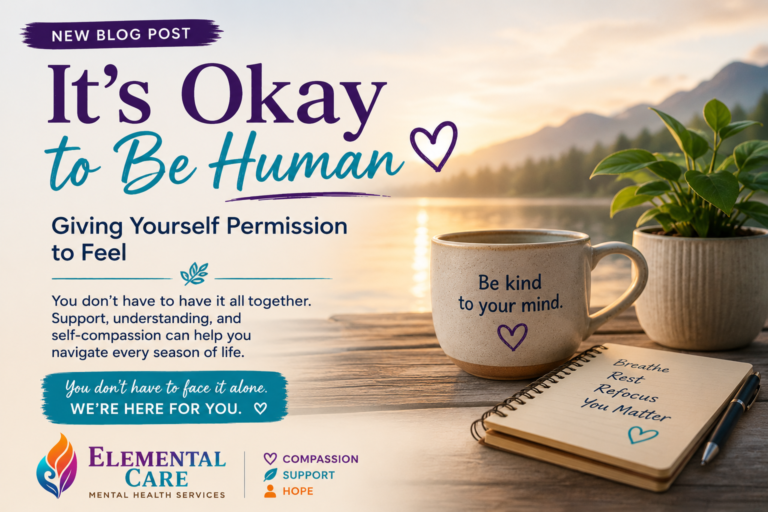 It's Okay to Be Human blog graphic featuring a peaceful lakeside sunrise, coffee mug, journal, and Elemental Care Mental Health Services branding promoting self-compassion and emotional wellness.